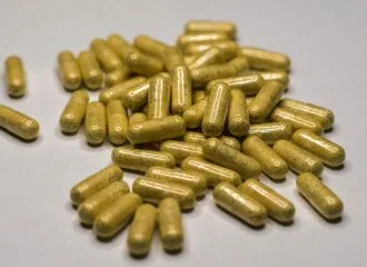 a pile of yellow pills sitting on top of a table