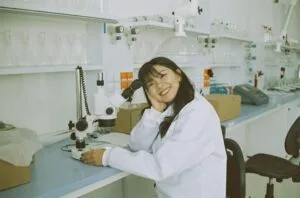 woman in white laboratory gown holding black instrument