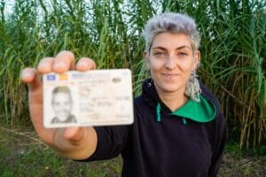 woman holding her license in a field