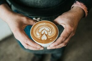 hands holding an espresso latte