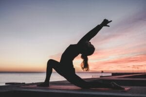 Woman doing yoga at sunset