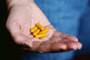 A hand holding herbal supplements