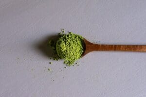 A wooden spoon full of kratom powder