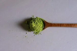 A wooden spoon full of kratom powder