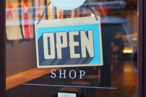 Glass door of a shop with a blue Open sign